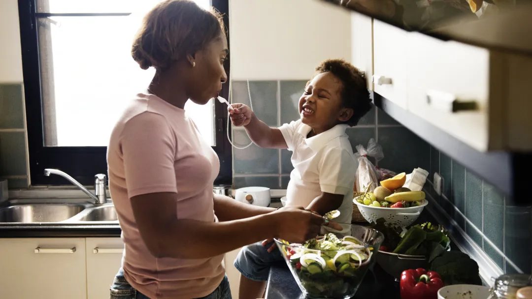 A mom prepares a meal for her family with the help of her toddler. 