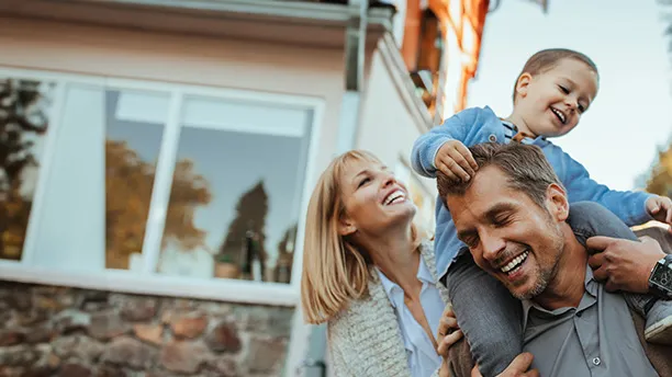 Smiling Parents with Son on Father's shoulders outdoors