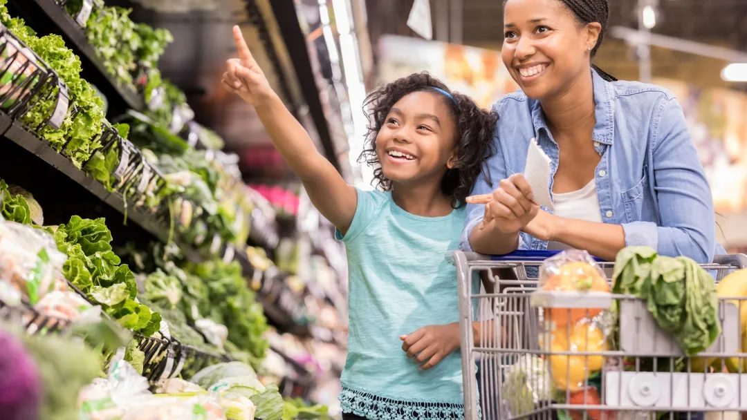 A mother and daughter shop for nutrient-rich vegetables at the supermarket. 