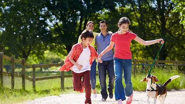 Family walking their dog along a dirt road