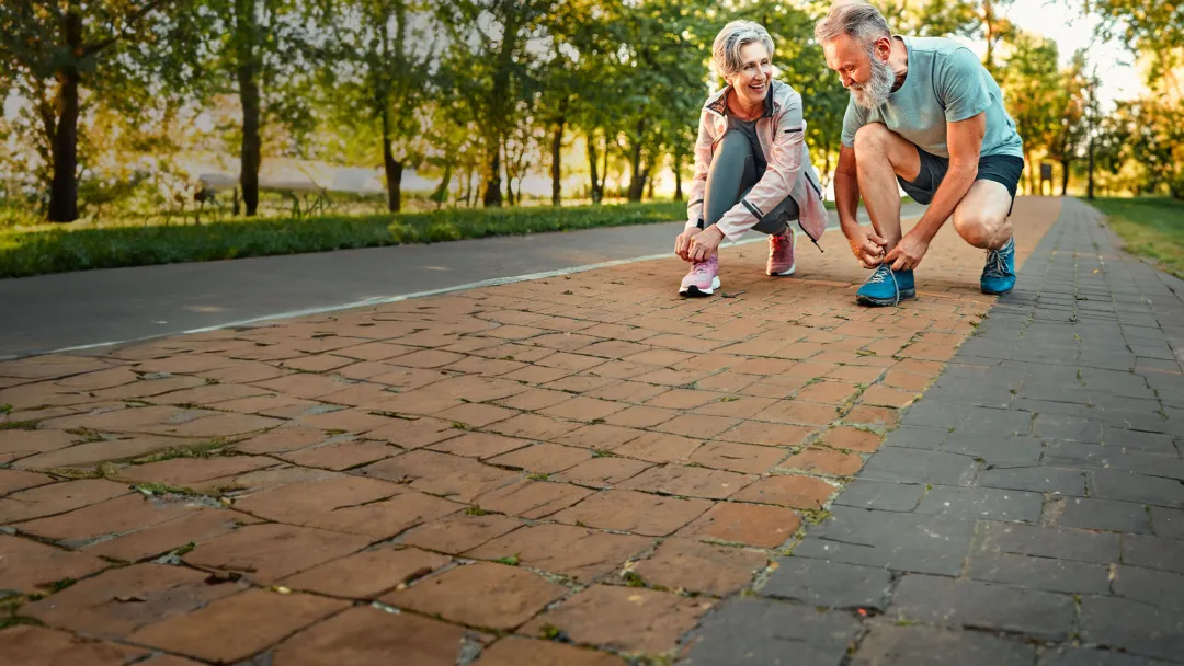 couple-squating-and-tying-their-shoes-while-smiling