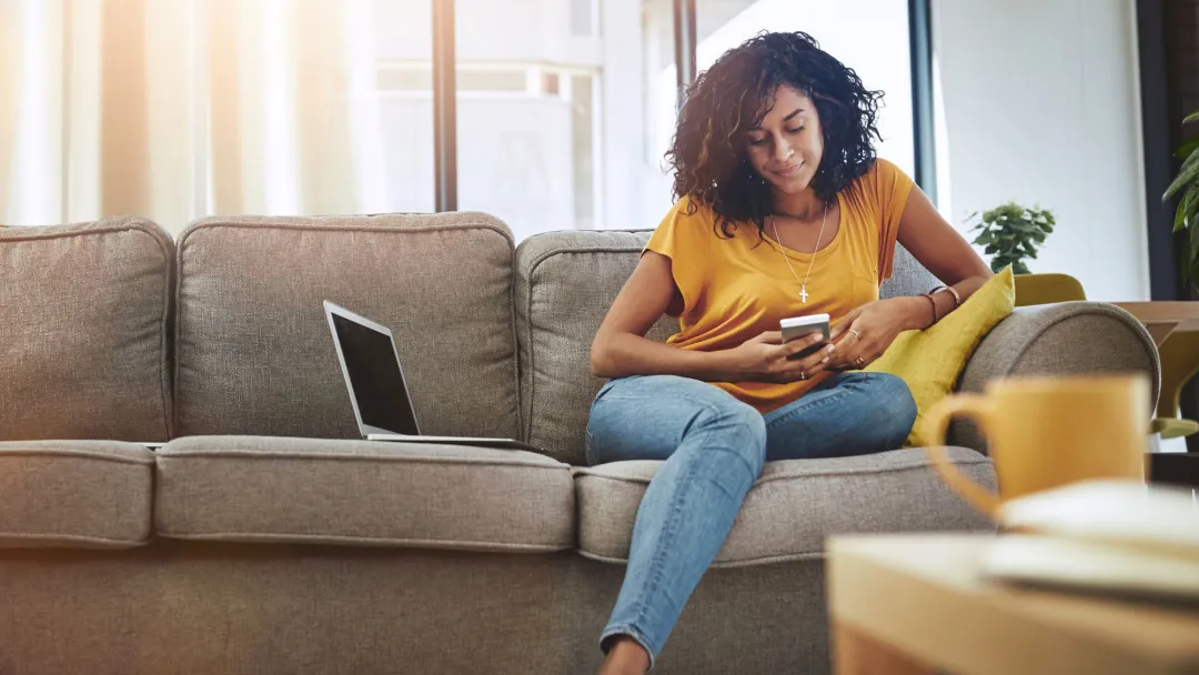 Woman reading phone on couch