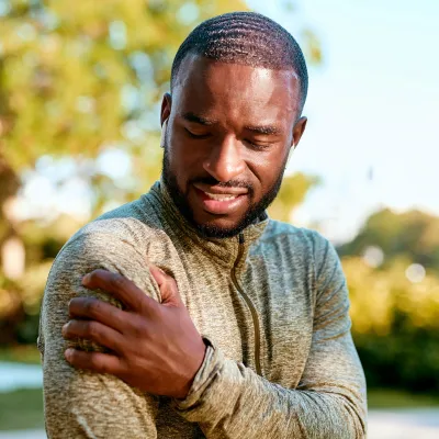 African American Man rubbing sore shoulder