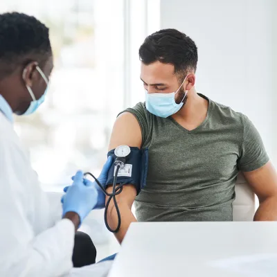 A Doctor Takes a Patient's Blood Pressure with a Blood Pressure Cuff
