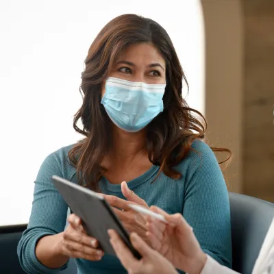 A Woman Consults With Her Doctor with a Tablet.