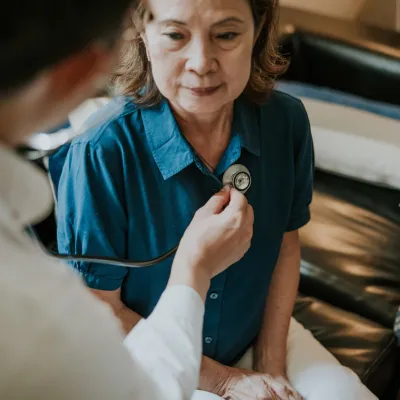 A Doctor Listens to a Patient's Heart with a Stethoscope 
