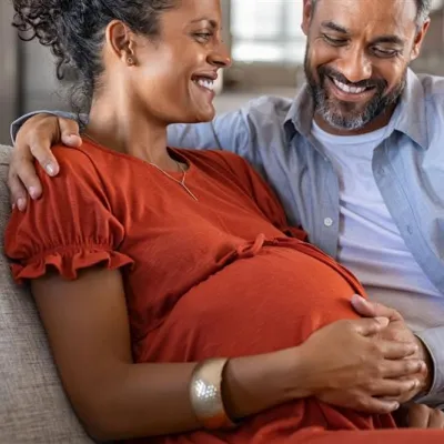 Pregnant couple sitting on couch