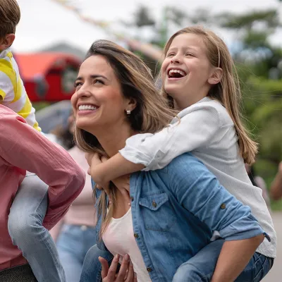 Two parents carrying on their backs their son and daughter.
