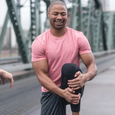 A man does a proper warm up to avoid injury.