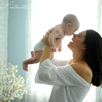 A woman holding her baby face to face.