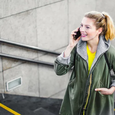A woman walking up stairs while talking on the phone