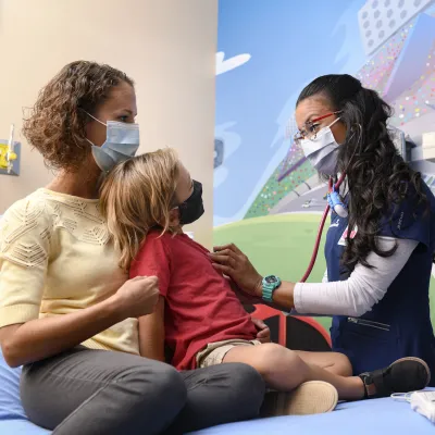 Pediatrician with young patient and mother