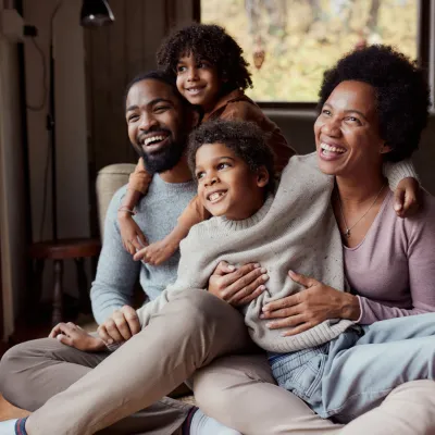 A happy African-American family looking out the window