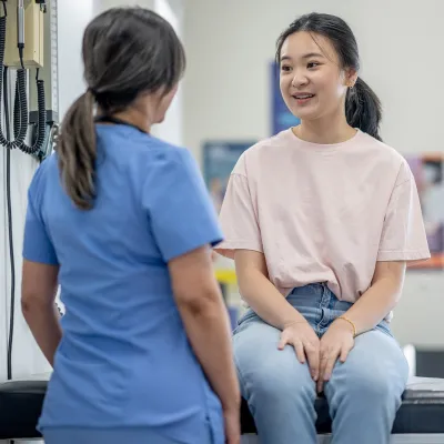 A young female patient speaks to her nurse.