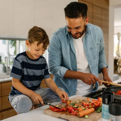 A father an son laugh together while preparing a healthy meal.
