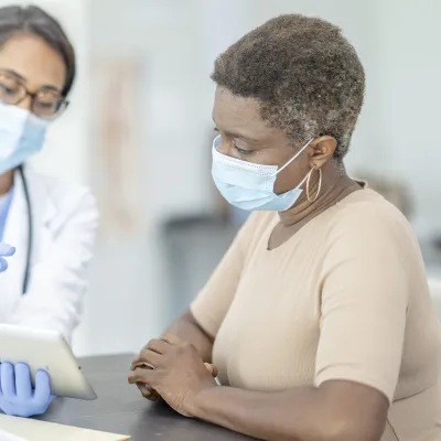 A woman at the doctor wearing a mask.
