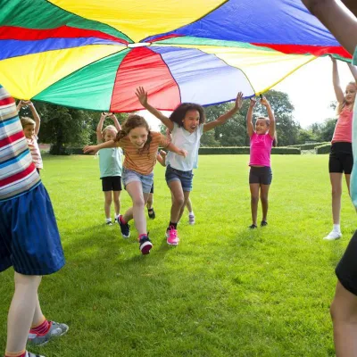 children-playing-outdoors-as-they-run-under-a-colorful-tent