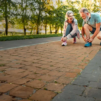 couple-squating-and-tying-their-shoes-while-smiling