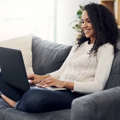 Young woman with laptop sitting on couch
