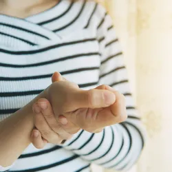 A woman holding her wrist