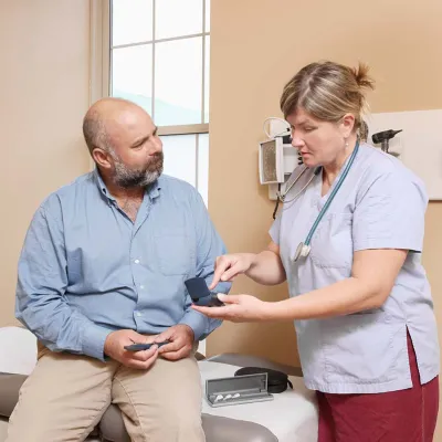 Nurse demonstrating a device to a patient