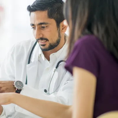 A doctor and a patient read a tablet.