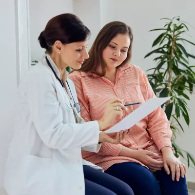 A woman and her healthcare provider looking at a document together.