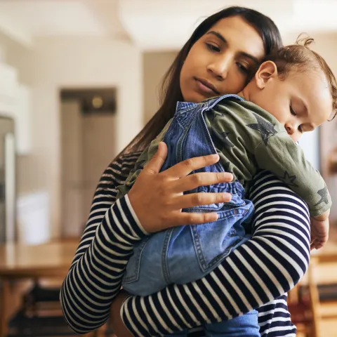 Mother holding young sleeping child