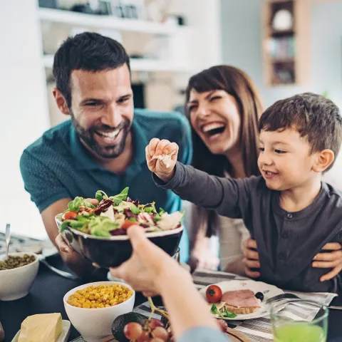  A Family Gathers Around The Kitchen Table To Enjoy Some Healthy Foods.