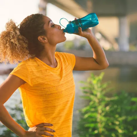 Woman on a run drinking water 