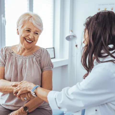 A Provider Holds a Smiling Patient's Hand