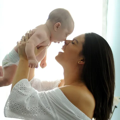 A mother holds her baby up.