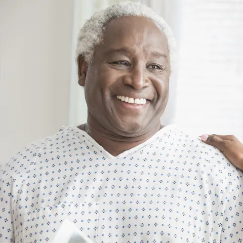 An older African American man receives consolation from a female physician.