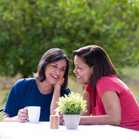 Two women sitting at a picnic table