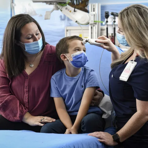 Pediatrician with boy and his mother in office