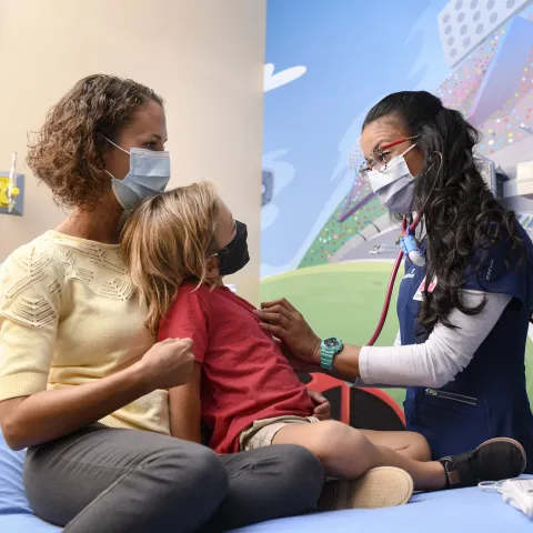 Pediatrician with young patient and mother