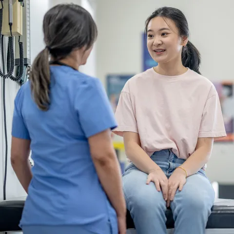 A young female patient speaks to her nurse.
