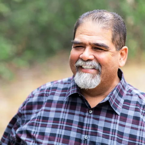 A mature man smiling and outdoors