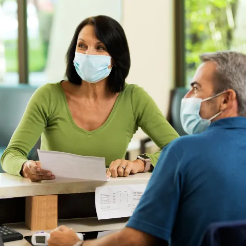 A woman getting help by a receptionist at AdventHealth Winter Park