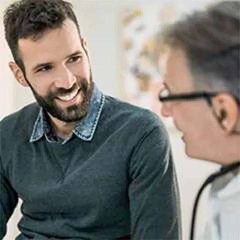 Young bearded man speaking with doctor