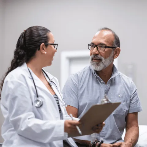 A middle-aged man talking to a female doctor.