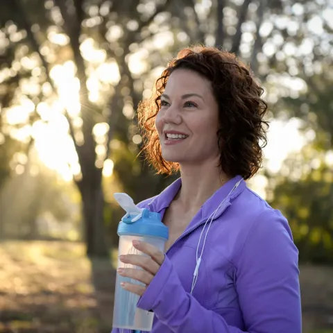 A woman outdoors taking a break from a run