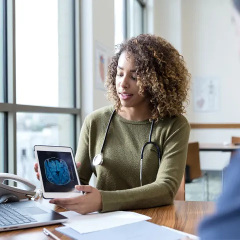 A patient and physician looking at a laptop screen
