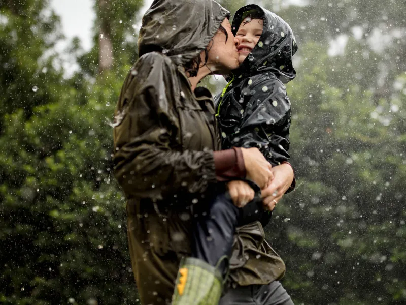 Mom and little boy playing in the rain.