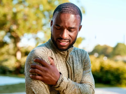 African American Man rubbing sore shoulder