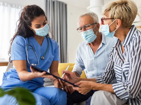 Nurse goes over information with a patient and their spouse.