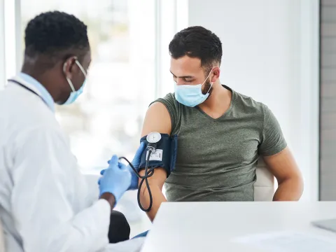 A Doctor Takes a Patient's Blood Pressure with a Blood Pressure Cuff