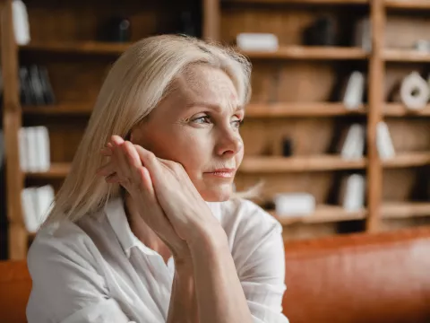 A Woman Thinks Deeply with Her Hand Pressed Against Her Face