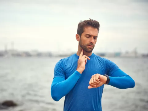 A Man Takes a Break From His Jog to Check His Pulse.