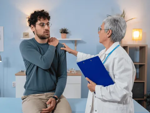 Man with Doctor holding his shoulder.